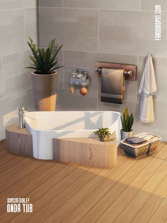 a bath tub sitting on top of a wooden floor next to a potted plant