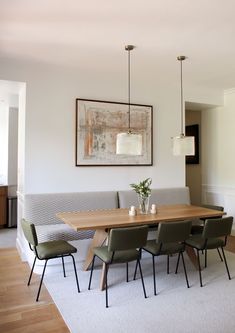 a dining room table with four chairs and a bench in front of it, next to a couch