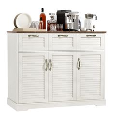 a white cabinet with many different items on it's top and bottom drawers,