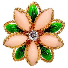 This lovely, Mid-20th Century 18K yellow gold Italian flower motif ring feels beautifully organic. The diamond in the center is surrounded by angel skin coral petals and transparent green enamel leaves. The diamond weighs approximately .17ct of G color and VS2 clarity. Measures 1 inch in diameter. It is stamped 18K Italy on the inside. Ring is a size 7 3/4. Gross weight 11.10 grams. Italian Flowers, Angel Skin, Coral Jewelry, Flower Motif, Diamond Flower, Fashion Ring, Green Enamel, Gold Flowers, Italian Fashion