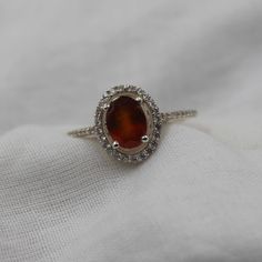 Handmade Product Description Gemstone : Natural Hessonite Garnet Stone Size : 6x8 MM Stone Shape : Oval Secondary Stone : Cubic Zirconia Gemstone : Cut Ring Size : All Size Available Band Color : Silver Made In (INDIA) Payment Policy We accept payment through PayPal Payment should be made within 3 days of purchase. Delivery Time It is Handmade Item So Item will be Shipped within 3 to 5 Days after payment receive. The delivery time usually takes 11 to 24 days, depending which Country & location. We recommend you contact your local customs office if you have questions about this. Feedback If you are not satisfied with your purchased items then contact with us first before leaving negative or neutral feedback or opening disputes. We believe in solving the issues. A positive feedback represent Amber Oval Topaz Ring For Wedding, Elegant Amber Rings With Accent Stones, Sterling Silver Crystal Halo Ring For Wedding, Sterling Silver Gemstone Halo Ring For Wedding, Amber Sterling Silver Rings For Anniversary, Amber Rings For Anniversary In Fine Jewelry Style, Sterling Silver Halo Birthstone Ring For Formal Occasions, Promise Oval Opal Ring In Sterling Silver, Sterling Silver Wedding Gemstones