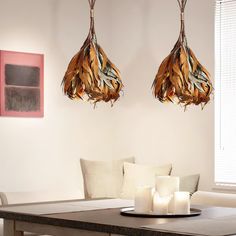 two lamps hanging from the ceiling above a table