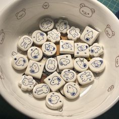 a bowl filled with lots of white and blue cartoon characters on top of each other