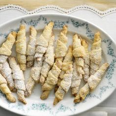 several pastries on a plate with powdered sugar