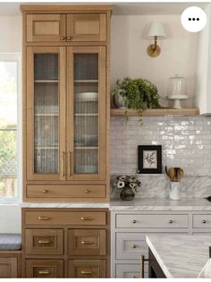 a kitchen with wooden cabinets and marble counter tops