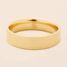 a yellow gold wedding ring with the letter b in it's center, on a white background