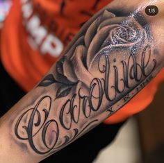 a man's arm with a rose and the word love written in cursive writing