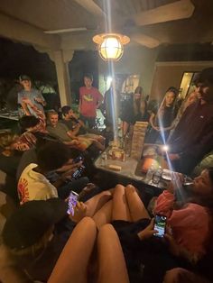 a group of people sitting around a table with cell phones in their hands and one person holding a smart phone