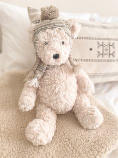 a white teddy bear sitting on top of a bed