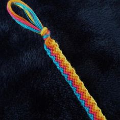 an orange, yellow and blue braided object on a black surface