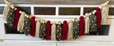 the garland is hanging on the wall by the window sill with beads and tassels