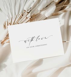 a white card with the words wife on it next to some feathers and an envelope