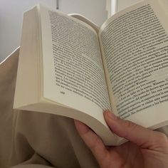 a person holding an open book in their hands