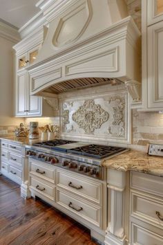 a large kitchen with white cabinets and marble counter tops, along with an oven in the center