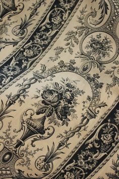 close up view of an intricately designed table cloth with black and white designs on it