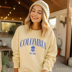 This Colombia sweatshirt has a preppy style, perfect for those who love a classic and comfortable look. Ideal for college students, young adults, and anyone who enjoys a relaxed and fashionable vibe. Great for casual wear, lounging at home, or running errands. Perfect for everyday wear. Product features - 1x1 Ribbed collar, cuffs and bottom hem for a well-fitted garment - Necktape for added comfort and stability - 80% cotton, 20% polyester fabric for a luxurious feel - Medium-heavy fabric for wa University Logo Sweatshirt For Campus, University Logo Sweatshirt For College, Casual Campus Sweatshirt With Lettering, Collegiate Letter Print Sweatshirt For Campus, College Style Letter Print Sweatshirt For Campus, Casual University Logo Sweatshirt For College, Casual College Sweatshirt With University Logo, Casual Long Sleeve Sweatshirt With University Logo, College Style Letter Print Sweatshirt For School