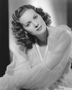 an old black and white photo of a woman with her hands on her chins