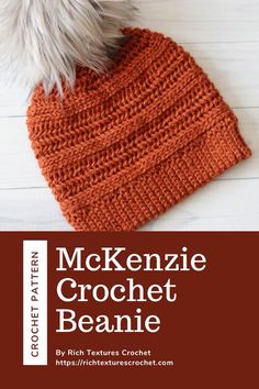 an orange knitted beanie with a white pom - pom on top