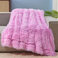 a fluffy pink blanket is sitting on a couch