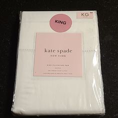 the king bedding is white and has pink dots on it