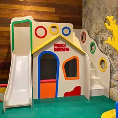 a child's play area with a slide and climbing wall