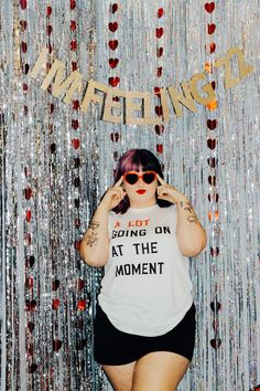 a woman with pink hair and sunglasses standing in front of a backdrop that says, i got going on at the moment