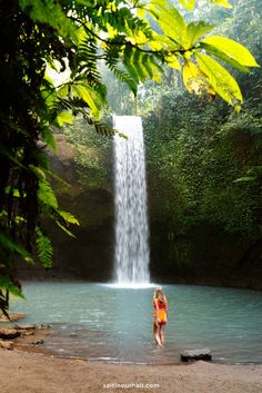 a woman standing in front of a waterfall