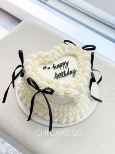 a heart shaped cake with the words happy birthday written on it is sitting on a table