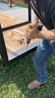 a man is drilling screws on the side of a trailer that's being built