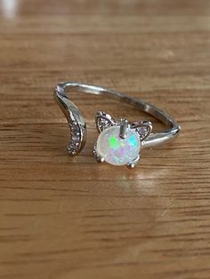 This super cute, silver tone, cat ring is very cute! It's is adjustable and has a small simulate opal in the center and small rhinestones in the tail. It's made of copper. It's a great small accessory to add to any outfit and show your love for your cat! Cute Silver Open Ring Jewelry, Cute Silver Open Ring, Anniversary Rings With Cat Design, Anniversary Cat Design Rings, Silver Anniversary Ring With Cat Design, Adjustable Cat Design Ring As Gift, Silver Ring With Cat Design For Anniversary, Adjustable White Jewelry With Cat Design, Cheap Rings With Cat Design For Gift