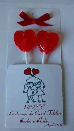 two red heart shaped lollipops on top of a card