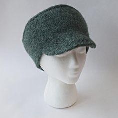 a white mannequin head wearing a green hat