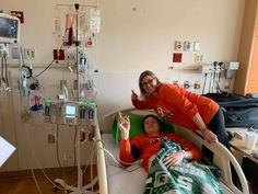 two people in a hospital bed giving the thumbs up