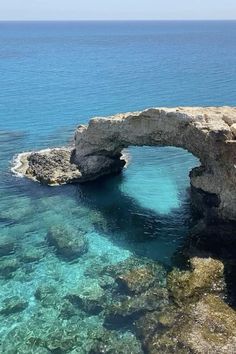 the water is crystal blue and clear with an arch in it's center, surrounded by large rocks