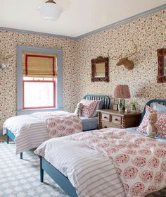 two twin beds in a bedroom with floral wallpaper