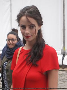 a woman in a red dress is posing for the camera