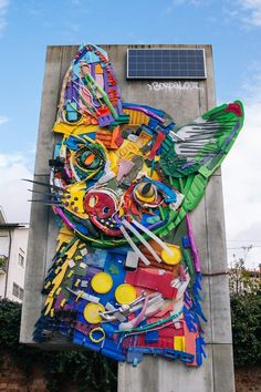 a large cat made out of many different types of items on the side of a building