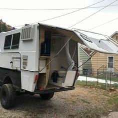 an rv parked on the side of a road with it's back door open