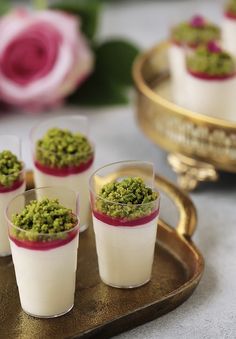 small glasses filled with food sitting on top of a tray