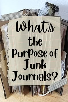 a pile of junk sitting on top of a wooden floor next to a sign that says, whats the purpose of junk journals?