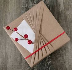 a brown box with red berries on it and some white paper tied to the side