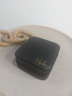 a small black case sitting on top of a white table next to a large chain