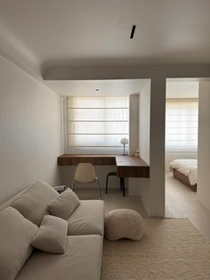 a living room with a couch, desk and bed in the corner next to each other