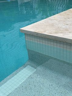 an empty swimming pool with tiled walls and flooring next to it is seen in this image