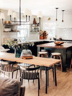 a kitchen filled with lots of counter top space and wooden flooring next to a dining room table