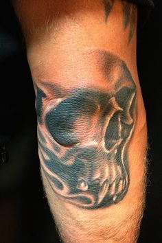 a man's arm with a skull tattoo on it and an eyeball in the middle