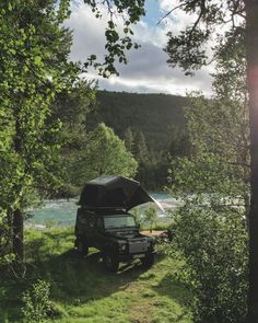 an suv parked in the woods next to a river