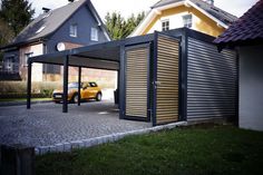 a yellow car is parked in front of a metal structure on the side of a road