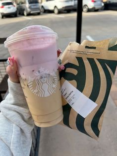 a person holding up a starbucks drink in their hand