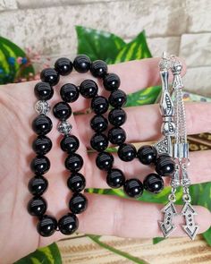 "✔️ This is a 33 pcs attractive tasbih made of AAA quality 10 mm shining black onyx beads. ✔️ It is a elegant and striking rosary. ✔️ This black ONYX tesbih is made from using Genuine Natural Onyx Stone NOT GLASS ONYX.. ✔️ Bead Size: 10 mm ✔️ Gemstone: Original Black Onxy ✔️ Total lenght: 32 cm (12.59 inches) ✔️ Each order comes in a special box. ✔️ PLEASE CLICK THE LINK FOR ALL PRAYER BEADS MODELS https://www.etsy.com/shop/GoodJewelsofYazmasal Note: As a natural feature the stones beads may hav Traditional Black Beads For Gift, Spiritual Black Beads For Jewelry Making, Traditional Black Rosary As Gift, Onyx Black Beads For Gifts, Handmade Spiritual Black Beads, Handmade Black Rosary For Gift, Black 8mm Beads For Gifts, Spiritual Black Beads With Silver Accents, Handmade Black Spiritual Beads